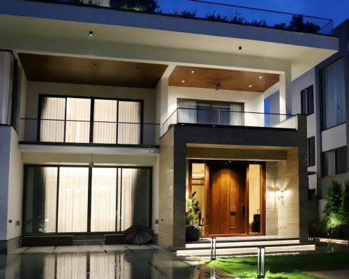 Stunning modern luxury house exterior lit up at night with clean architectural design.